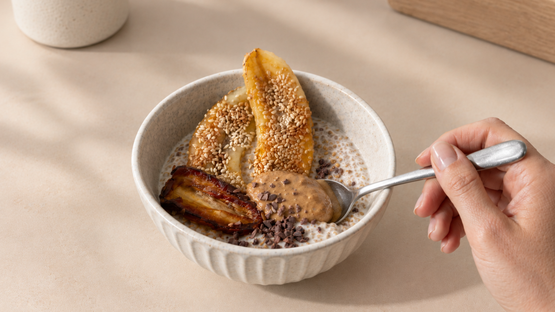 Bowl of cinnamon collagen chia pudding topped with sliced banana, dates, and peanut butter.